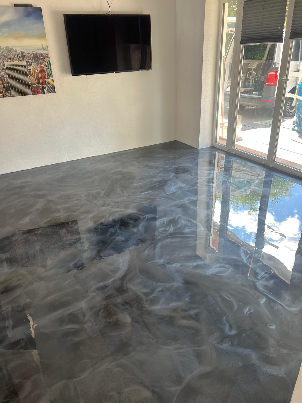 Glänzender grauer Epoxidharzboden mit Fensterreflexionen
