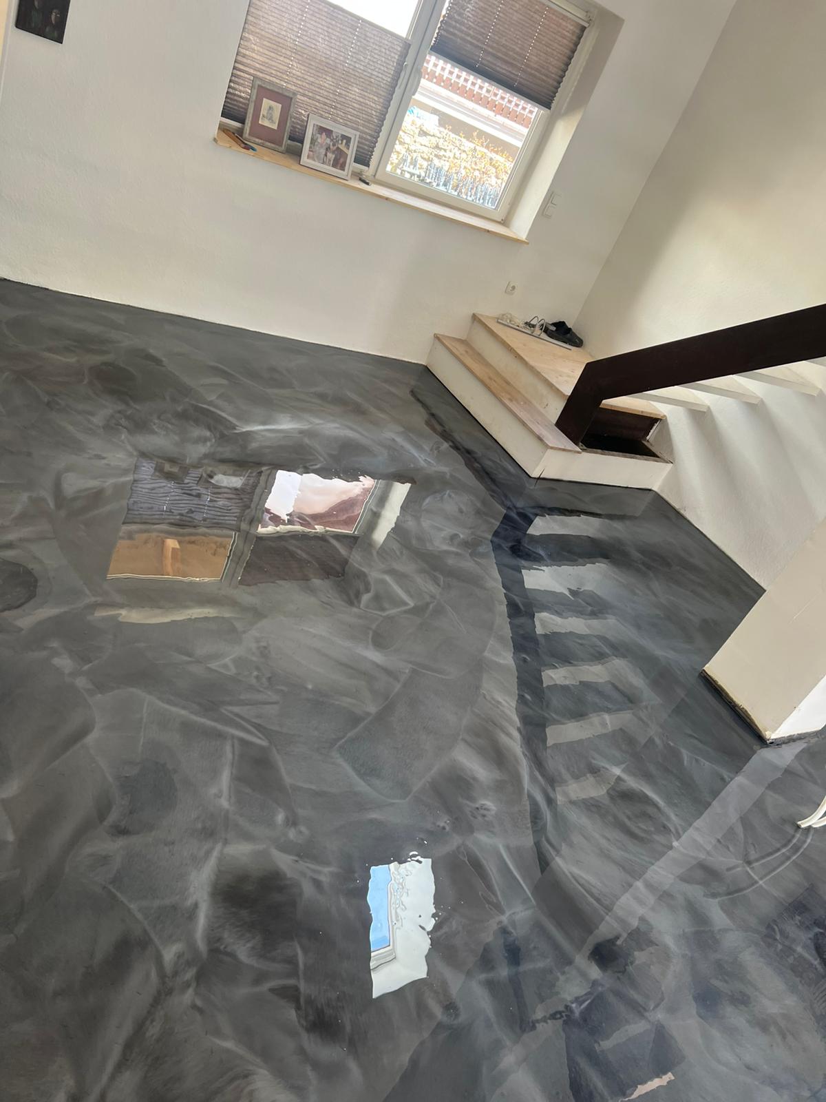 Grauer Epoxidharzboden mit Marmorstruktur und Spiegelungen an einer Treppe